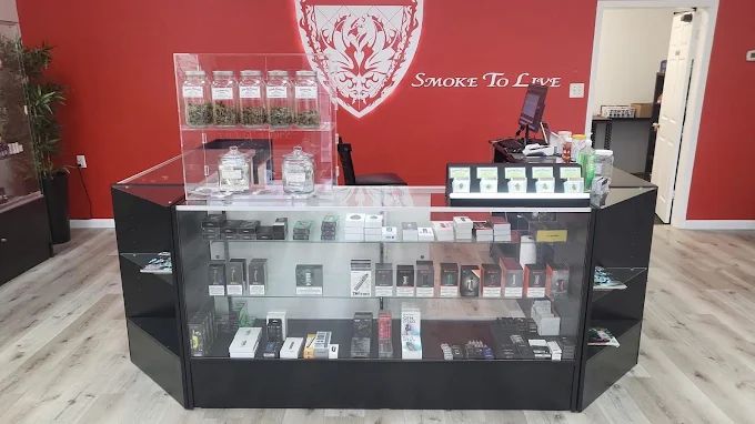 Sales counter and vape display cases under the Smoke To Live crest logo, Nacogdoches Rd San Antonio